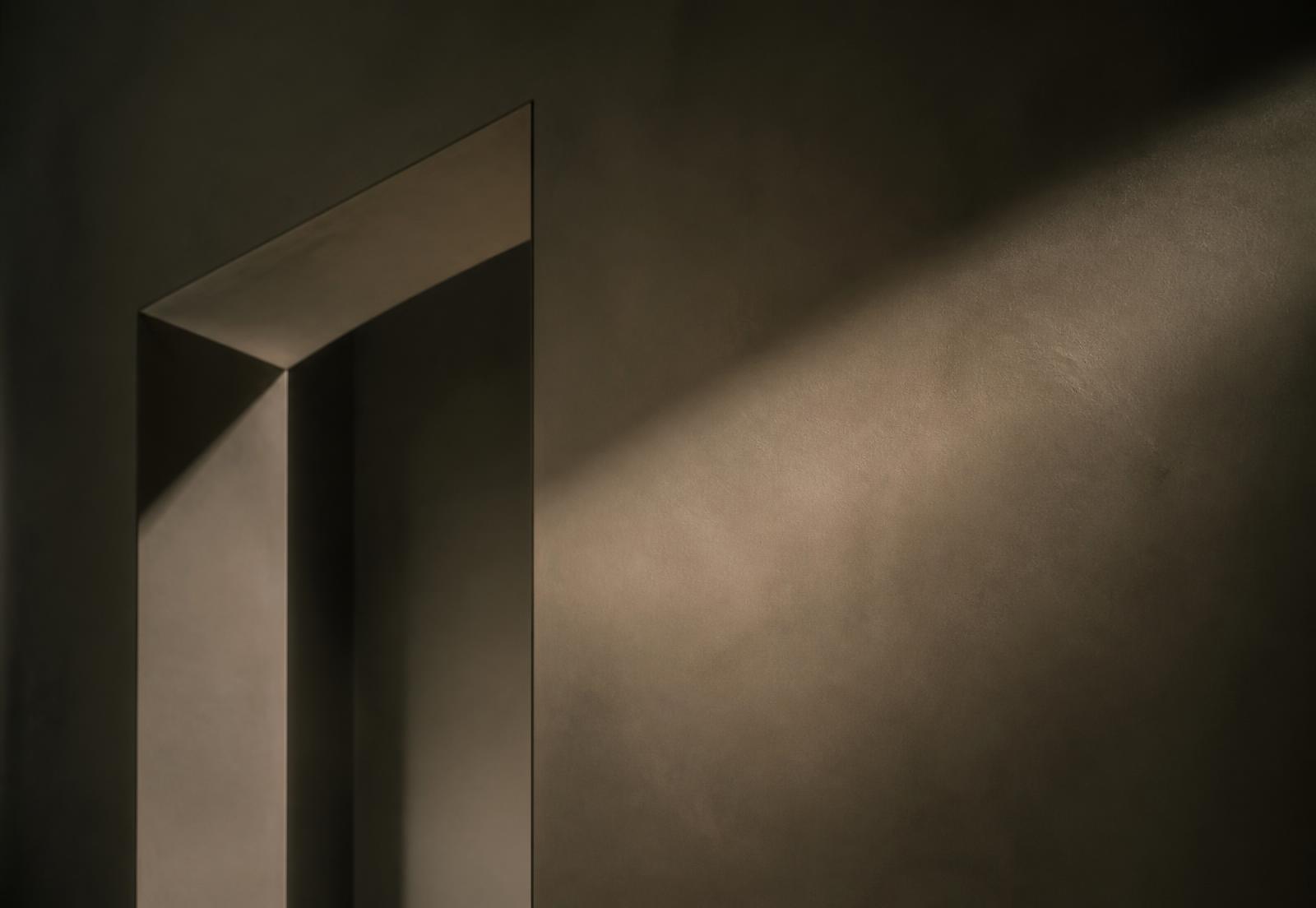 Soft daylight raking across a minimal architectural interior